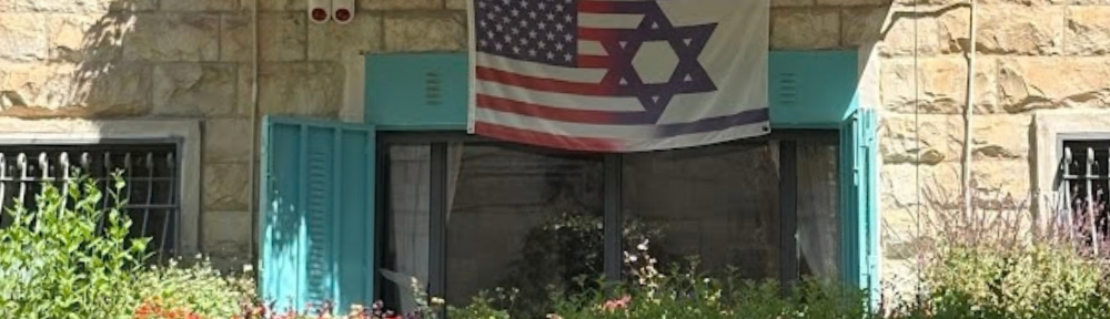 American and Israeli flags hanging above a window.